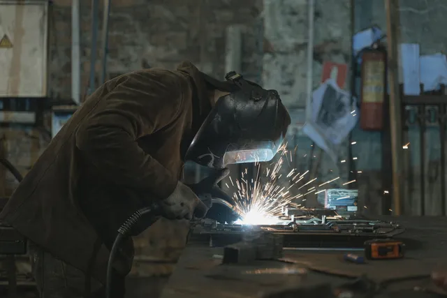Craftsman welding a metal piece in the workshop